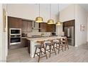 Modern kitchen with stainless steel appliances, a center island with seating, and stylish pendant lighting at 11813 Pippa Ave, Las Vegas, NV 89138