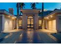 Elegant home entrance with an ornate front door, well-lit porch, and attached two-car garages at 1665 Liege Dr, Henderson, NV 89012