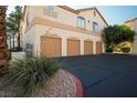 Exterior of a multi-unit building featuring garage doors and well-maintained landscaping at 1830 N Buffalo Dr # 1031, Las Vegas, NV 89128