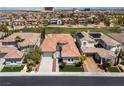 View of the home's tile roof in a desert community near a golf course with city views in the distance at 2080 Orchard Mist St, Las Vegas, NV 89135