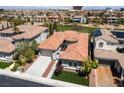 Aerial view of the home's tile roof and a neighborhood near a golf course with city views in the distance at 2080 Orchard Mist St, Las Vegas, NV 89135