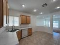 Bright kitchen with tile floor, stainless sink, marble countertops, wood cabinets, and white appliances at 3029 Frigate Way, North Las Vegas, NV 89084