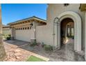 Tan stucco home featuring a two-car garage, brick accents, and a gated courtyard entrance at 3614 Coventry Gardens Dr, Las Vegas, NV 89135