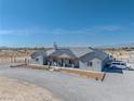 Charming single-story home with grey exterior, covered porch, and well-manicured gravel driveway at 3880 Rudek St, Pahrump, NV 89061