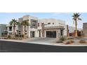Contemporary home featuring a multi-car garage, striking architecture, and lush landscaping for curb appeal at 4024 Desert Trace Ct, Las Vegas, NV 89129