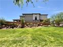 Contemporary two-story home showcasing a well-manicured lawn and tidy shrubbery at 4132 Ancient Well Ct, Las Vegas, NV 89135