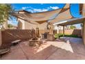 Outdoor living space with built-in grill, fire pit, and shade sails for entertaining at 4133 Perfect Lure St, Las Vegas, NV 89129