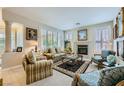 Cozy living room with a fireplace, plantation shutters, neutral walls, and comfortable seating arrangement at 4187 Pacifico Ln, Las Vegas, NV 89135