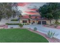 Well-manicured lawn and desert landscaping frame this home, complete with a circular driveway and mature trees at 4594 Blue Mesa Way, Las Vegas, NV 89129