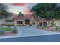 Expansive front exterior of a desert home features manicured landscaping and a circular driveway leading to a stately entrance at 4594 Blue Mesa Way, Las Vegas, NV 89129