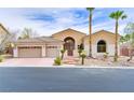 Exterior of home features desert landscaping, palm trees, and a three car garage at 4624 Leon De Oro Dr, Las Vegas, NV 89129