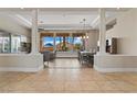 Spacious living and dining area with large windows, tray ceiling, and elegant columns at 4624 Leon De Oro Dr, Las Vegas, NV 89129