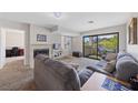 Comfortable living room featuring neutral carpet, a fireplace, and sliding glass doors to a balcony at 4865 S Torrey Pines Dr # 206, Las Vegas, NV 89103