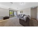 Spacious living room with neutral carpet, a comfortable gray sectional, and sliding glass doors to a balcony at 4865 S Torrey Pines Dr # 206, Las Vegas, NV 89103