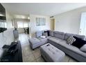 Cozy living room featuring a comfortable gray sectional sofa and tile flooring at 6212 Burgundy Way, Las Vegas, NV 89107