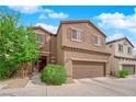 Charming two-story home with a two-car garage and desert landscaping under a bright blue, partly cloudy sky at 9024 Hazy Haven Ct, Las Vegas, NV 89149