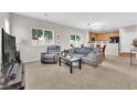Bright living room featuring neutral walls, carpet flooring, comfortable seating, and a sliding glass door to the backyard at 9024 Hazy Haven Ct, Las Vegas, NV 89149
