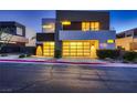 Modern home featuring a two-car garage with illuminated glass doors and contemporary design at 917 Vegas View Dr, Henderson, NV 89052