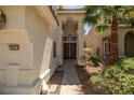Elegant front entry with double doors, desert landscaping, and exterior lighting at 9491 Gainey Ranch Ave, Las Vegas, NV 89147