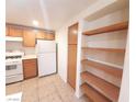 This kitchen offers wood cabinets, white appliances, and a pantry, set on neutral-toned tile floors at 9580 W Reno Ave # 183, Las Vegas, NV 89148