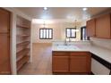 Open concept kitchen features wood cabinets, a breakfast bar, and modern appliances, with views into the dining and living areas at 9580 W Reno Ave # 183, Las Vegas, NV 89148