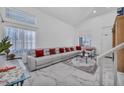 Bright living room featuring high ceilings, large windows, and a comfortable sectional sofa at 103 Trout Creek Ct, Las Vegas, NV 89123