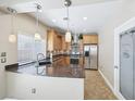 Well-lit kitchen featuring granite countertops, stainless steel appliances, and a frosted pantry door at 10601 India Hawthorn Ave, Las Vegas, NV 89144
