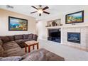 Comfortable living room with a tile fireplace and built-in niche, plus plantation shutters at 11219 Castellane Dr, Las Vegas, NV 89141