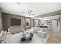 Comfortable living room with large TV, modern furnishings, and view into the bright dining area at 11618 Costa Linda Ave, Las Vegas, NV 89138
