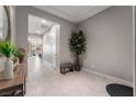 Neutral hallway with porcelain tile floor, white doors, and faux tree decor at 12843 New Providence St, Las Vegas, NV 89141