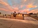 Charming single-story home with gated driveway and desert landscaping at sunset at 1615 Palora Ave, Las Vegas, NV 89169