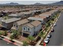 An aerial view of a neighborhood showcasing rooftops and street layout with mountain views in the distance at 169 Volti Subito Way, Henderson, NV 89011