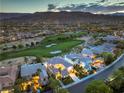 Breathtaking aerial view showcases a stunning home overlooking a lush golf course, surrounded by mountain views at 2571 Red Springs Dr, Las Vegas, NV 89135