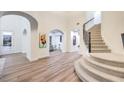 Bright foyer featuring wood floors, staircase, white walls, and arched doorways at 2571 Red Springs Dr, Las Vegas, NV 89135