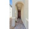 Inviting front entrance with arched doorway and brick pathway leading to a red front door with potted flowers at 2932 Tranquil Brook Ave, Henderson, NV 89044