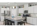 Modern kitchen with stainless steel appliances, granite countertops, white cabinets, and a large island with seating at 2932 Tranquil Brook Ave, Henderson, NV 89044
