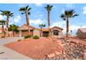 Beautiful single-story home boasting a two-car garage, rock accents and mature palm tree landscaping at 3157 Faiss Dr, Las Vegas, NV 89134