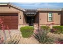 Inviting front of house with well-kept landscaping, stone accents, a covered porch and a three car garage at 4818 Al Carrison St, Las Vegas, NV 89149