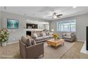 Bright living room with stylish furniture, neutral paint, ceiling fan, and view into the kitchen at 4818 Al Carrison St, Las Vegas, NV 89149