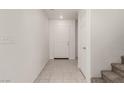 Well-lit entryway features tile flooring, white walls, a coat closet, and a carpeted staircase at 519 Brinkburn Point Ave, Las Vegas, NV 89178
