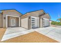 Close up shot of a house featuring a three-car garage, decorative front door and desert landscaping at 5251 Graystone, Pahrump, NV 89061