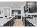 Modern kitchen featuring sleek dark cabinets, stainless steel appliances, and quartz countertops at 713 Webber Park St, Henderson, NV 89011