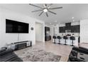 Open-concept living area with modern ceiling fan and adjacent kitchen island with bar stool seating at 713 Webber Park St, Henderson, NV 89011