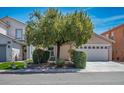 Inviting two-story home with manicured front yard, tree, lush landscaping, and a two-car garage at 7572 Hope Valley St, Las Vegas, NV 89139