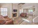 Cozy living area features a fireplace, wood flooring, and multiple windows for natural light at 8308 Tide Pool Dr, Las Vegas, NV 89128