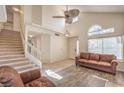 Bright living room with high ceilings, large windows, and a mix of tile and wood flooring at 8308 Tide Pool Dr, Las Vegas, NV 89128
