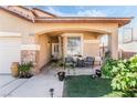 Welcoming front porch with cozy seating, complemented by desert landscaping and a covered entrance at 8345 Spruce Meadows Ave, Las Vegas, NV 89131