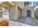 Inviting home entrance with a blue arched front door, a paved walkway, and lush landscaping at 9020 Tiffany Oaks Ave, Las Vegas, NV 89148