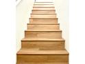 A close-up of light wood stairs in a bright home interior at 10372 Beautiful Fruit St, Las Vegas, NV 89183