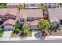 Aerial shot of this lovely home with a red tiled roof, surrounded by lush landscaping and neighboring properties at 10409 Snowdon Flat Ct, Las Vegas, NV 89129